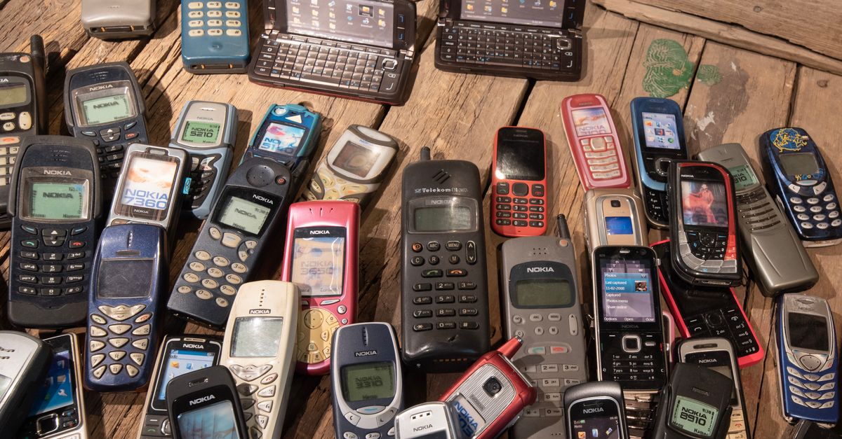 An assortment of retro mobile phones displayed on a rustic wooden surface, showcasing nostalgia.