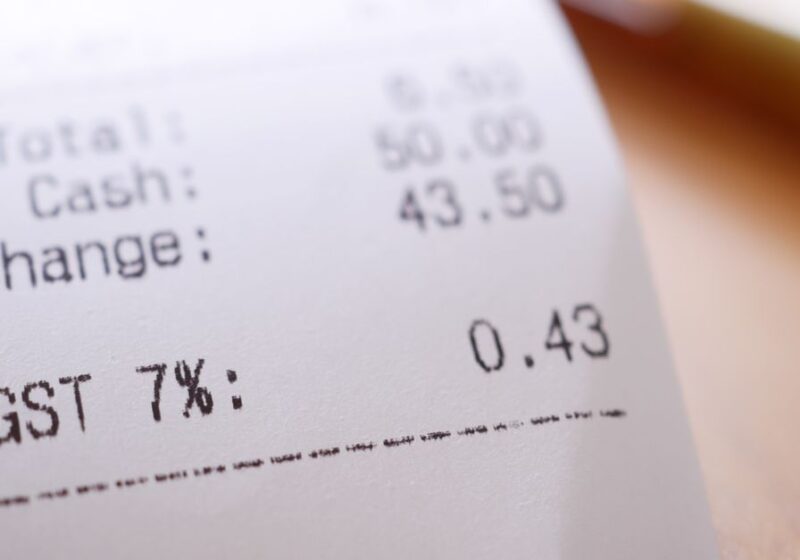 Detailed close-up image of a shopping receipt showing GST and total changes.