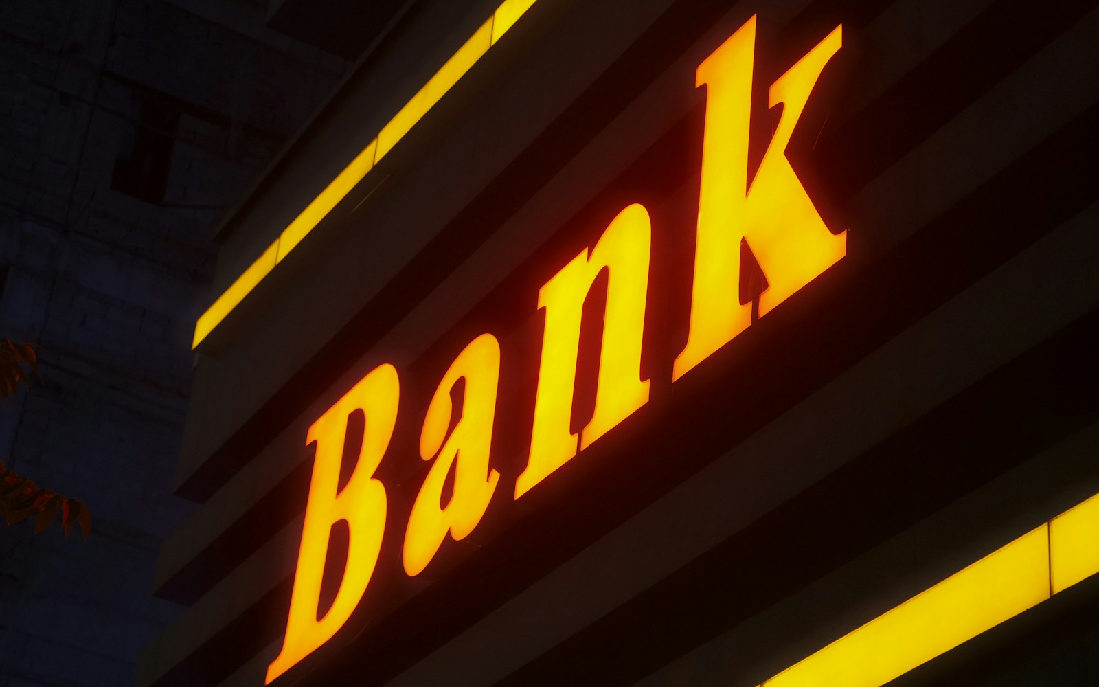 a bank sign lit up in the dark