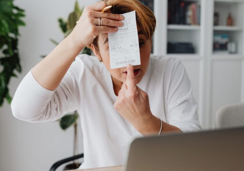 Businesswoman showing a receipt during a home office work session, highlighting technology integration.