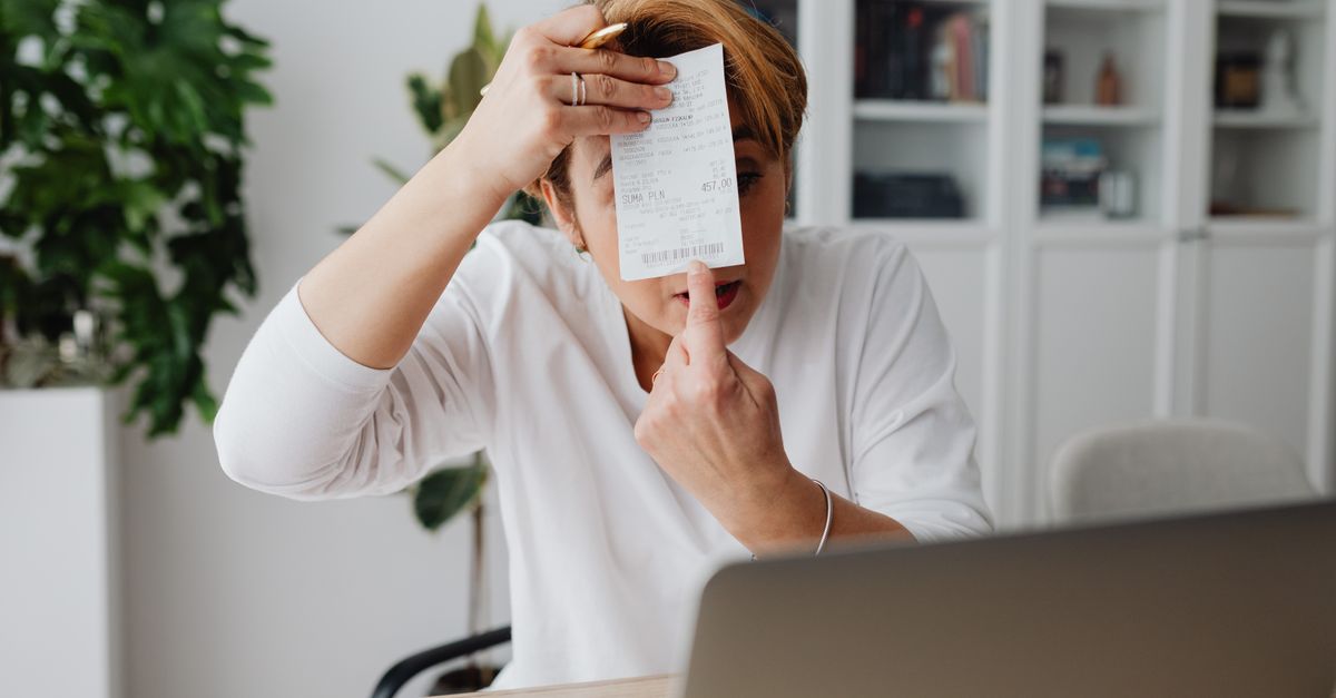 Businesswoman showing a receipt during a home office work session, highlighting technology integration.