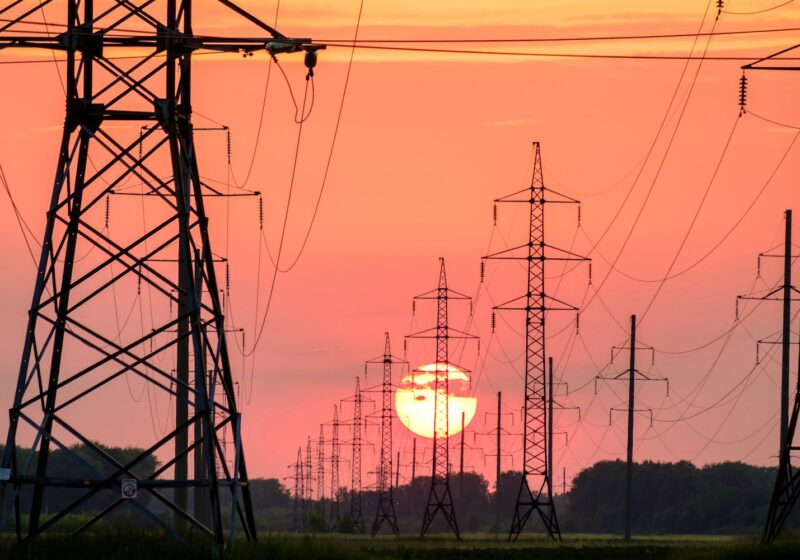 silhouette of electric post during sunset