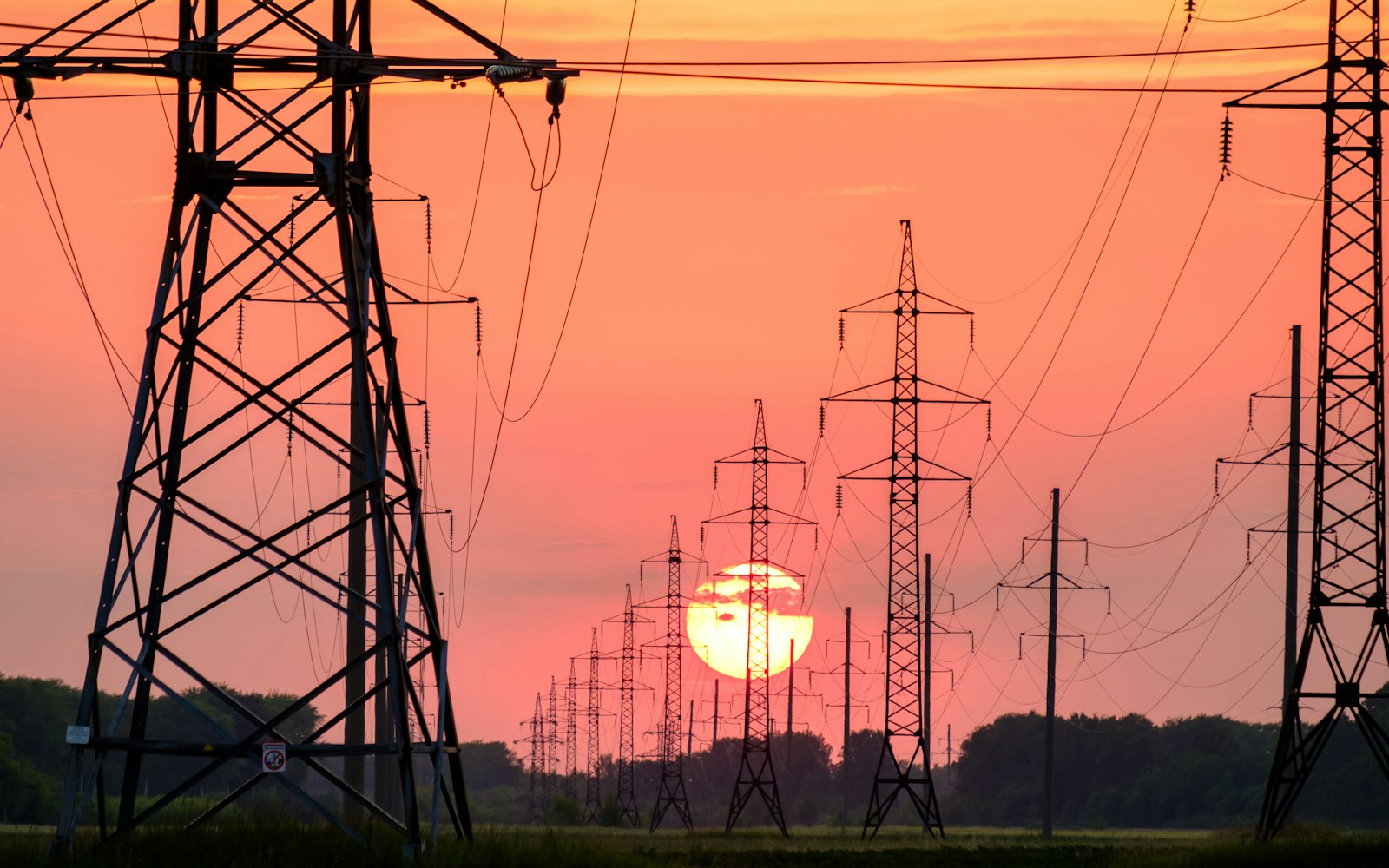 silhouette of electric post during sunset
