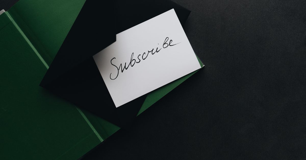 A minimalist image of a 'Subscribe' card in a green envelope on a dark background.