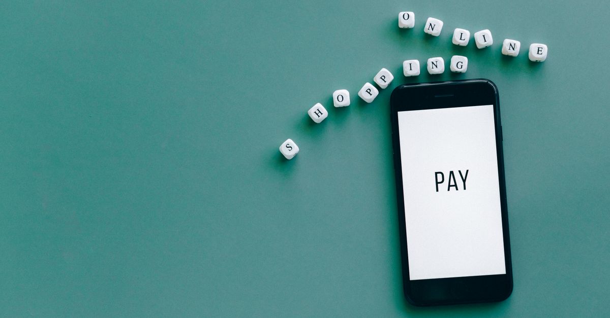 Image of smartphone displaying 'PAY' surrounded by dice spelling 'online shopping' on teal background.