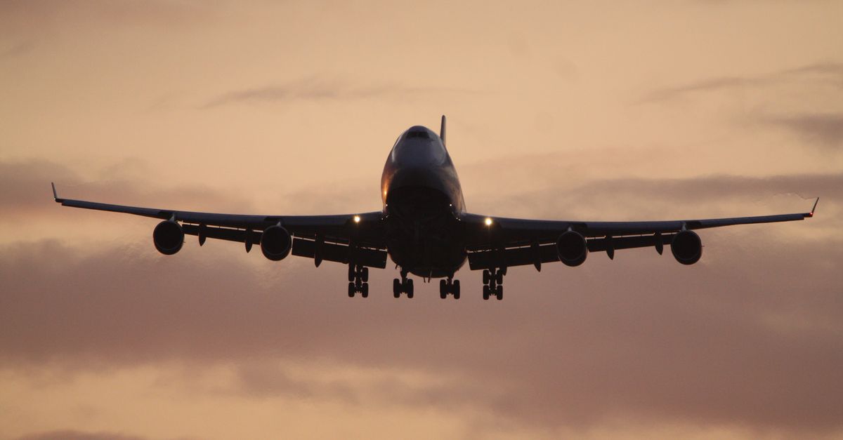 A passenger airplane silhouetted against a vibrant sunset sky, capturing the essence of travel.