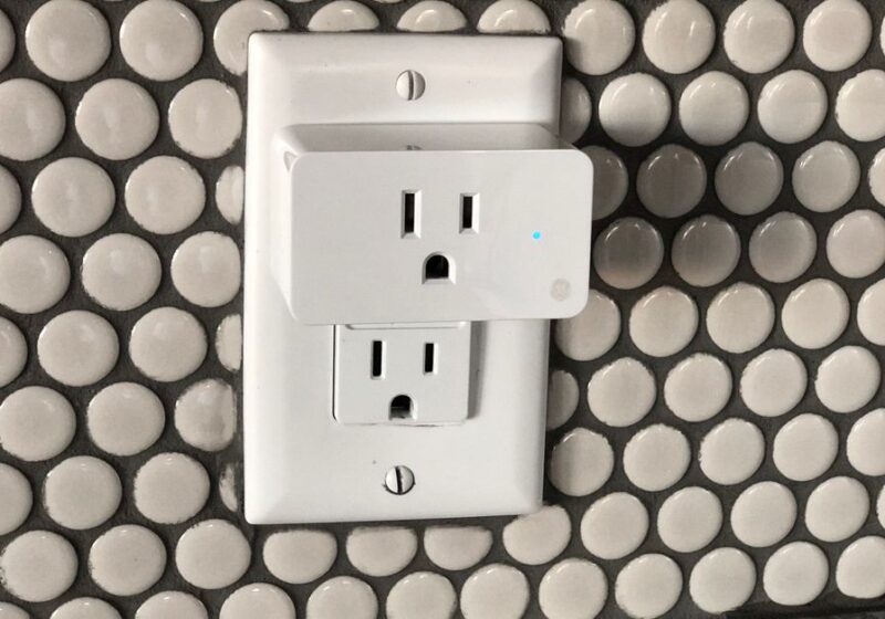 Close-up of a smart plug on a tiled wall showcasing contemporary interior design style.