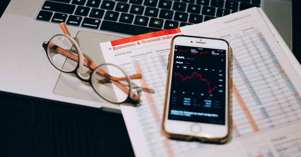 A detailed look at financial tools including a smartphone and laptop for stock analysis.